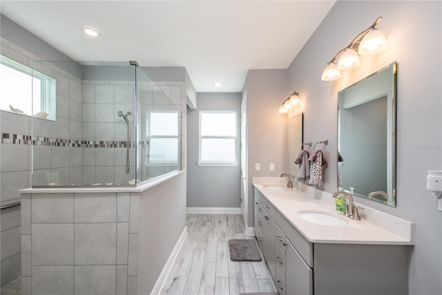 bathroom featuring tiled shower, vanity, and wood-type flooring