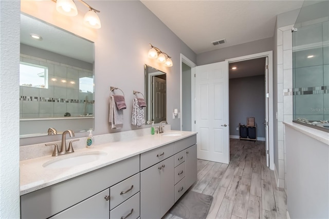 bathroom with a shower, wood-type flooring, and vanity