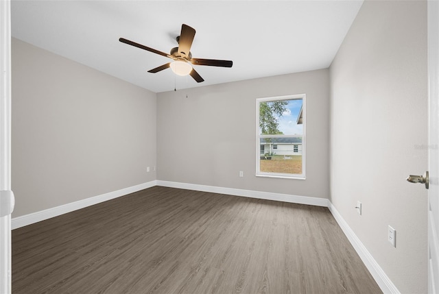 empty room with dark hardwood / wood-style floors and ceiling fan