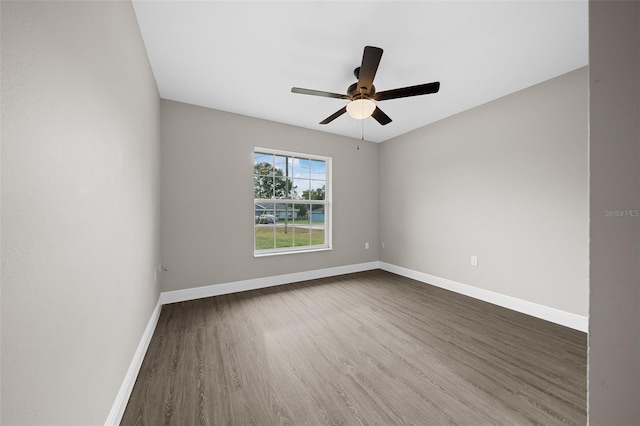 spare room with ceiling fan and dark wood-type flooring