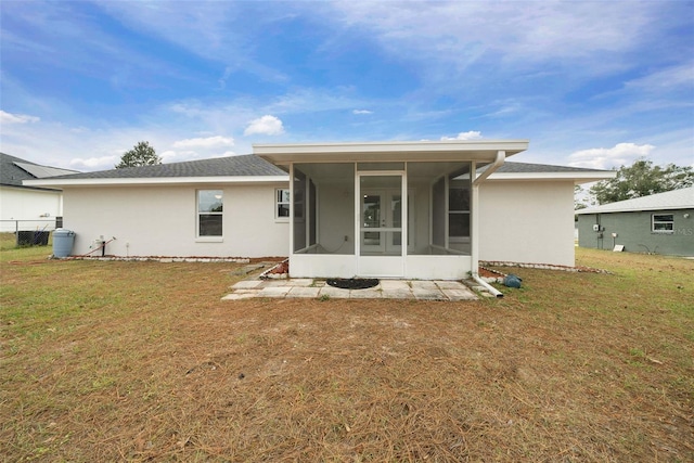 rear view of property with a lawn and a sunroom