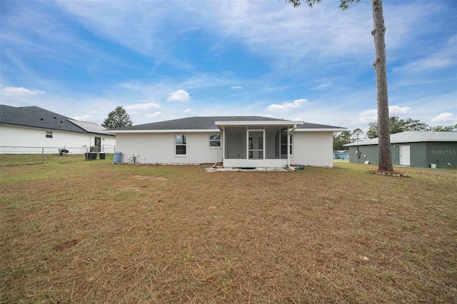 rear view of property with a sunroom, central air condition unit, and a lawn