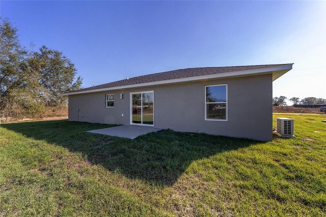 rear view of property with stucco siding, a patio, central AC, and a yard