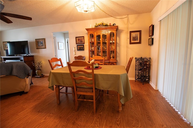 dining room with hardwood / wood-style floors, a textured ceiling, and ceiling fan