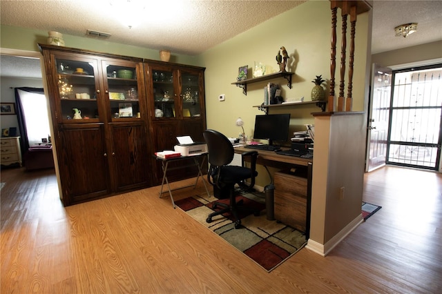 office space featuring a textured ceiling and light wood-type flooring