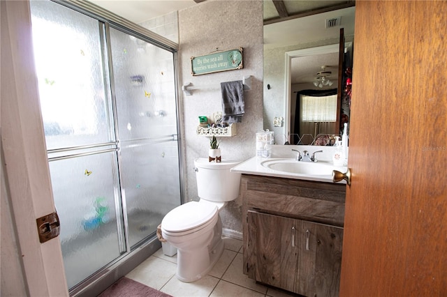 bathroom with tile patterned floors, vanity, a shower with shower door, and toilet