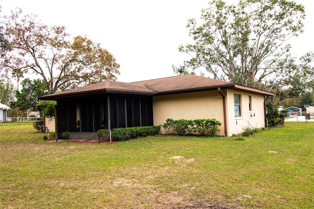 back of property with a sunroom and a lawn