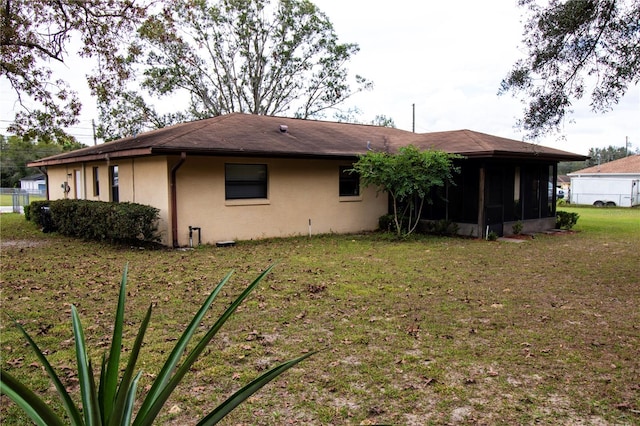 back of house featuring a yard and a sunroom