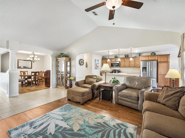 living room featuring ceiling fan with notable chandelier, light hardwood / wood-style floors, and high vaulted ceiling