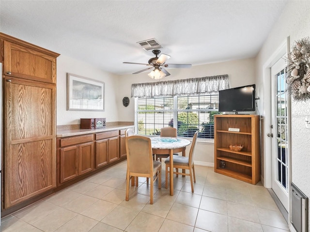 tiled dining area featuring ceiling fan and a textured ceiling