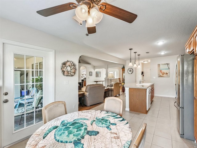 tiled dining space featuring ceiling fan, sink, and a textured ceiling