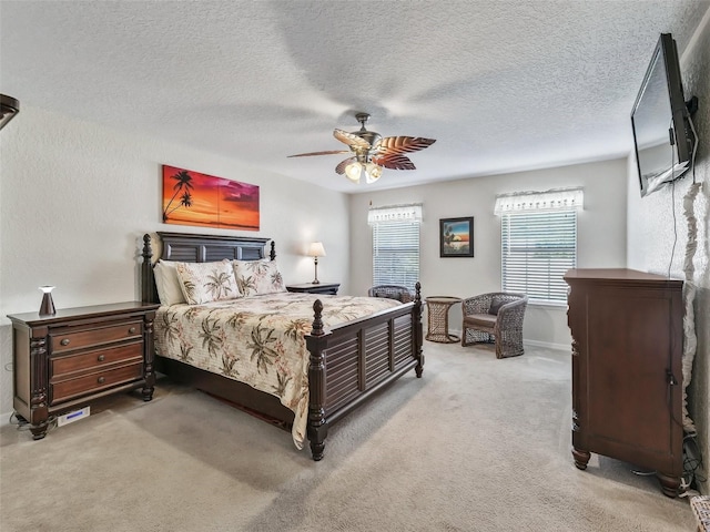 bedroom featuring light carpet, a textured ceiling, and ceiling fan