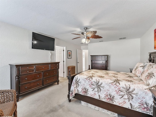 carpeted bedroom with ceiling fan and a textured ceiling