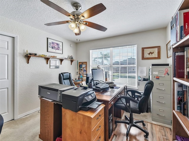 office area featuring light wood-type flooring, a textured ceiling, and ceiling fan