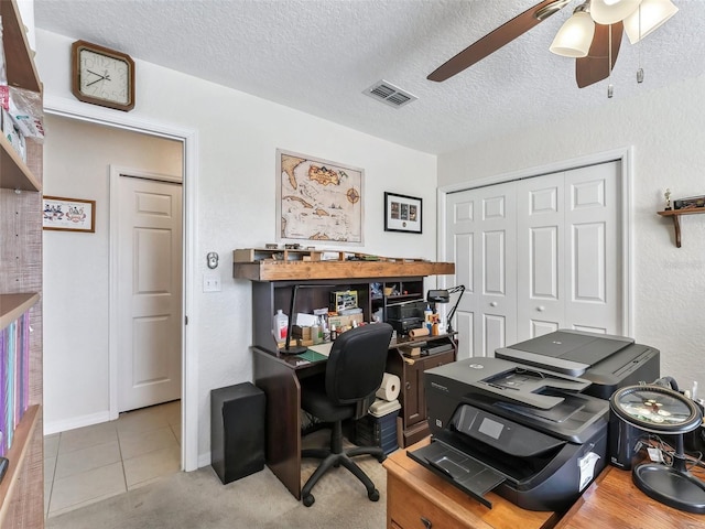 tiled home office featuring a textured ceiling and ceiling fan