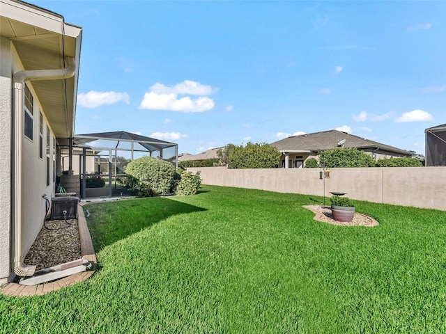 view of yard with glass enclosure and central AC