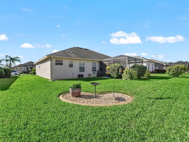 rear view of house featuring a yard and a lanai