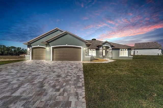 ranch-style home with an attached garage, stucco siding, decorative driveway, and a front yard