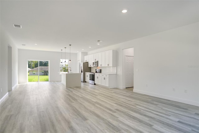 unfurnished living room featuring light wood-type flooring and sink