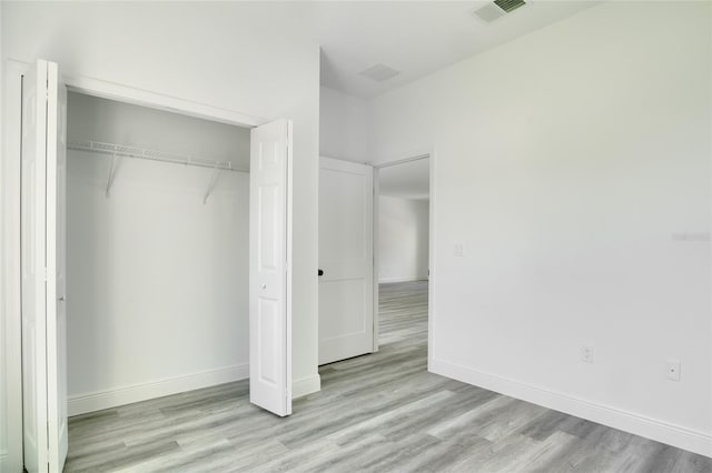 unfurnished bedroom with a closet and light hardwood / wood-style flooring