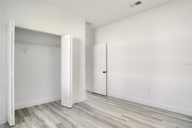 unfurnished bedroom featuring light wood-type flooring and a closet