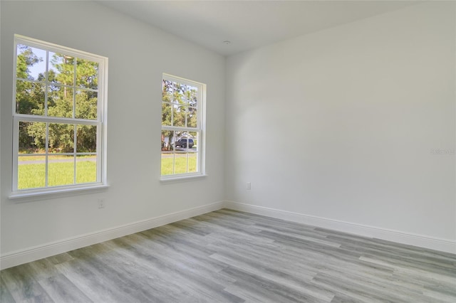 unfurnished room with a healthy amount of sunlight and light hardwood / wood-style flooring