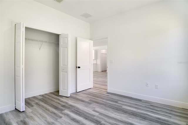 unfurnished bedroom with a closet and light wood-type flooring