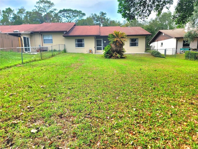 rear view of property featuring a yard