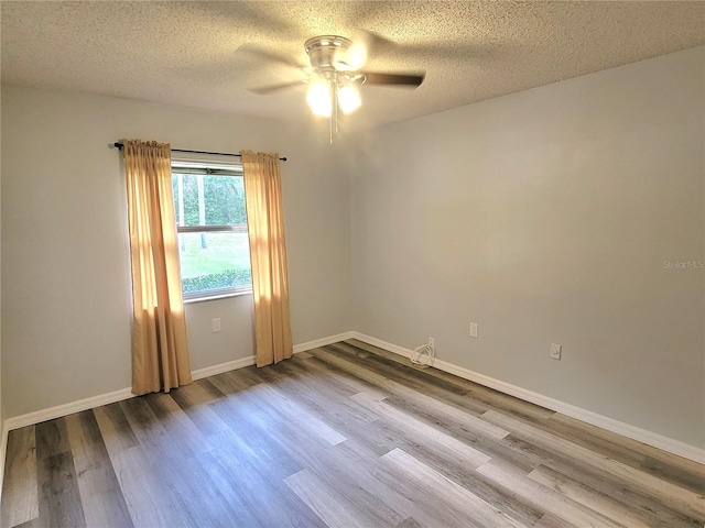 unfurnished room with hardwood / wood-style flooring, ceiling fan, and a textured ceiling