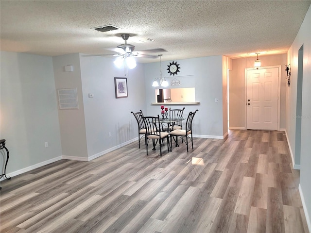 dining area featuring hardwood / wood-style floors, ceiling fan, and a textured ceiling