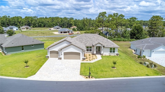 view of front of home featuring an attached garage, decorative driveway, and a front yard