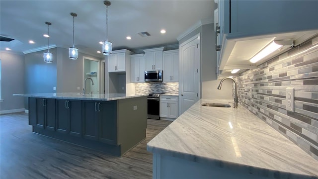 kitchen with a large island, light stone counters, hanging light fixtures, stainless steel appliances, and a sink