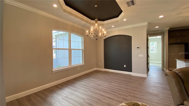 interior space featuring light wood finished floors, baseboards, visible vents, and a tray ceiling