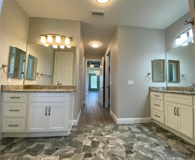 full bathroom featuring two vanities, marble finish floor, visible vents, and baseboards