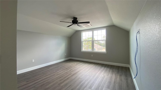 additional living space with lofted ceiling, dark wood-style flooring, and baseboards