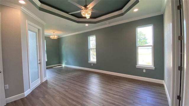 unfurnished room with ornamental molding, a raised ceiling, and a healthy amount of sunlight