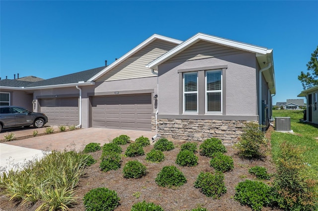 view of front of property with a garage and central AC