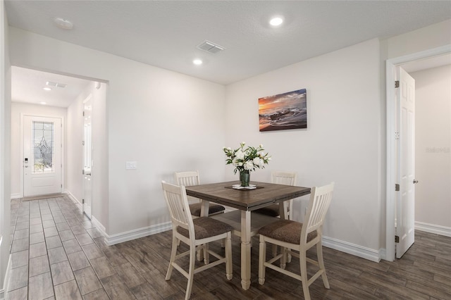 dining area with dark wood-type flooring and a textured ceiling