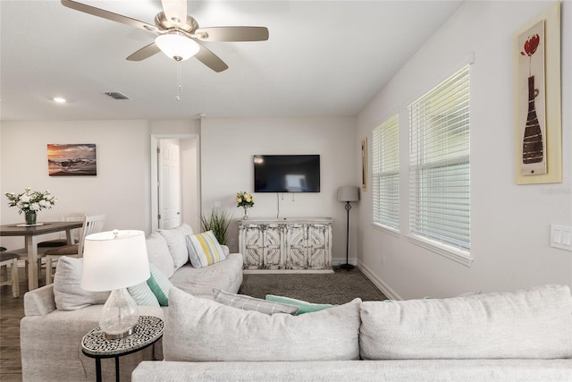 living room featuring ceiling fan and dark hardwood / wood-style floors