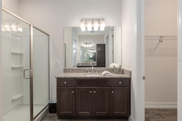 bathroom with vanity, an enclosed shower, and hardwood / wood-style flooring