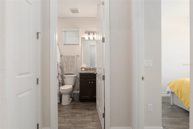 bathroom featuring toilet, vanity, and wood-type flooring