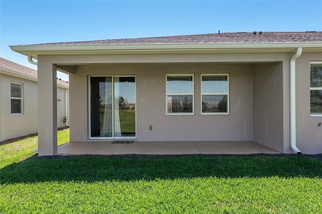 back of property with a lawn and a patio area