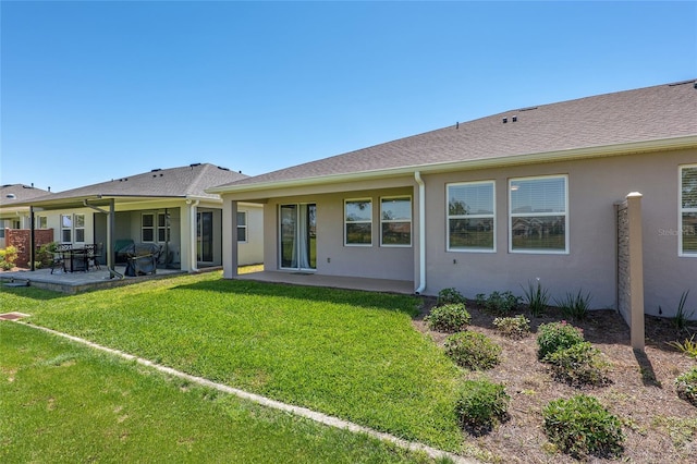 back of property with a patio area and a yard