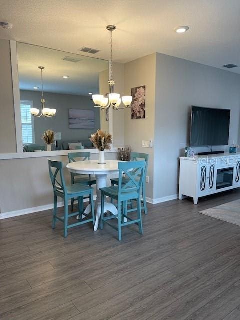 dining space with dark hardwood / wood-style floors and a chandelier