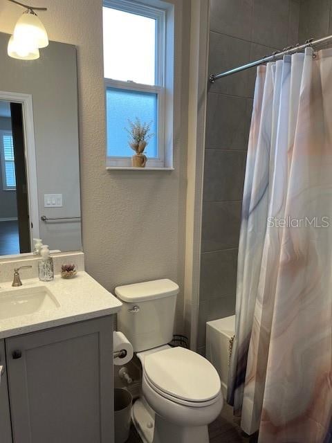 full bathroom featuring vanity, shower / bath combination with curtain, and toilet