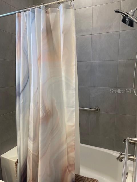 bathroom with shower / bath combo with shower curtain