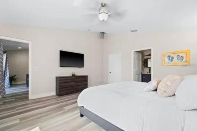 bedroom featuring hardwood / wood-style flooring, ceiling fan, and connected bathroom