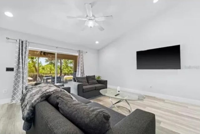 living room with light wood-type flooring, ceiling fan, and vaulted ceiling