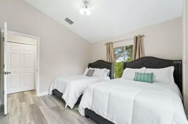 bedroom with light hardwood / wood-style flooring and lofted ceiling