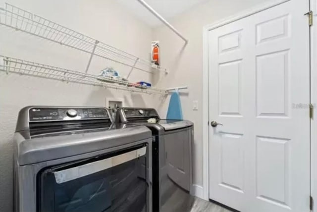 laundry area with hardwood / wood-style floors and washer and dryer